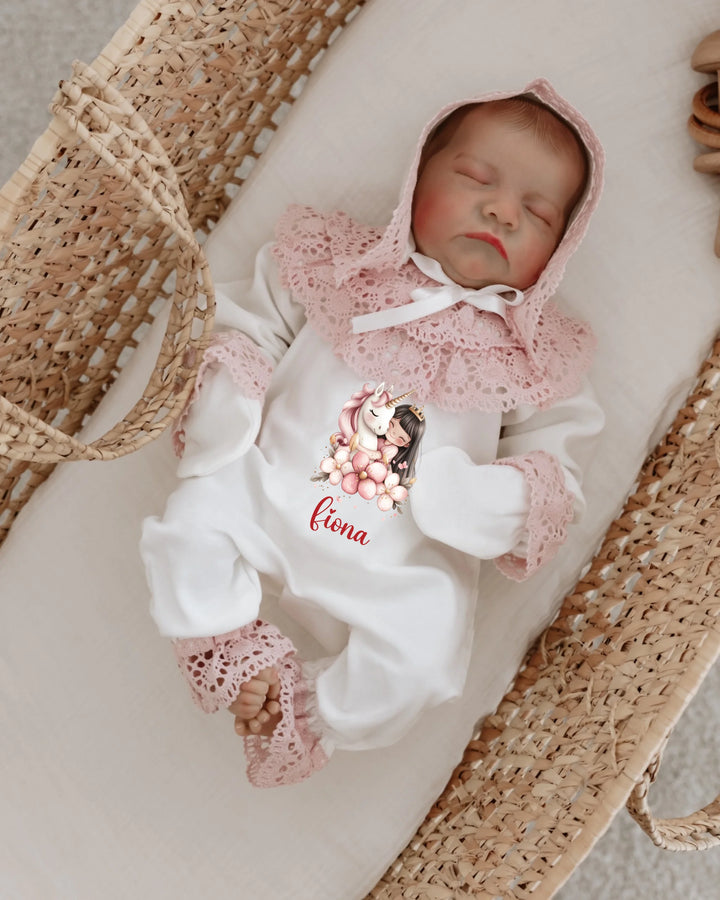 Baby girl in a personalized unicorn-themed romper with lace details, resting peacefully in a cozy basket.