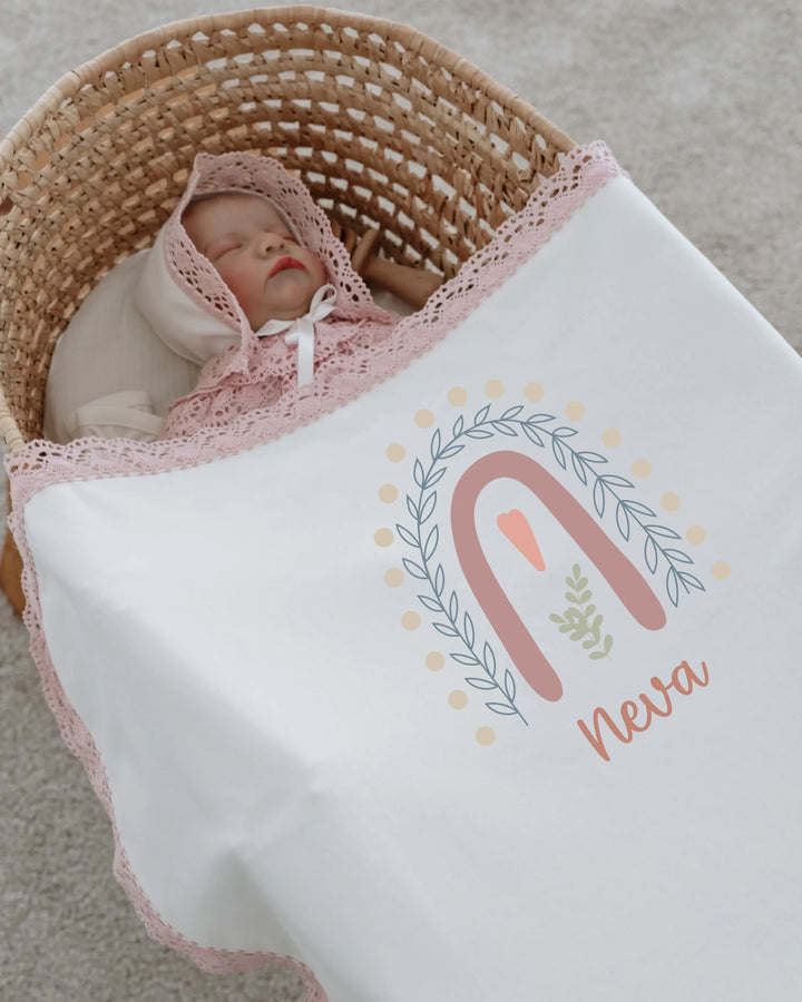 Gepersonaliseerd newborn dekentje met regenboogillustratie en de naam Neva voor meisjes.