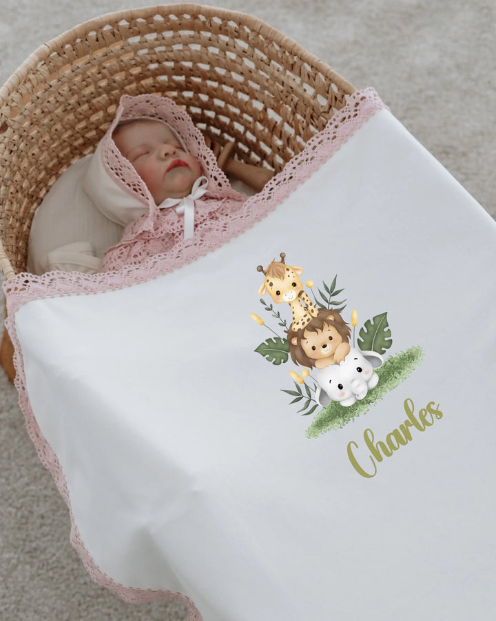 Gepersonaliseerde babydeken met safari dierenprint en naam Charles voor pasgeboren meisje in wieg.