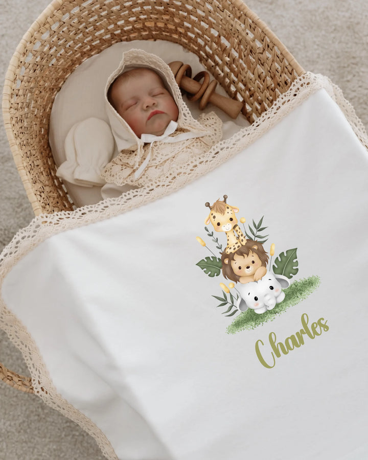 Newborn baby peacefully sleeping in a basket, wrapped in a personalized safari animal blanket.