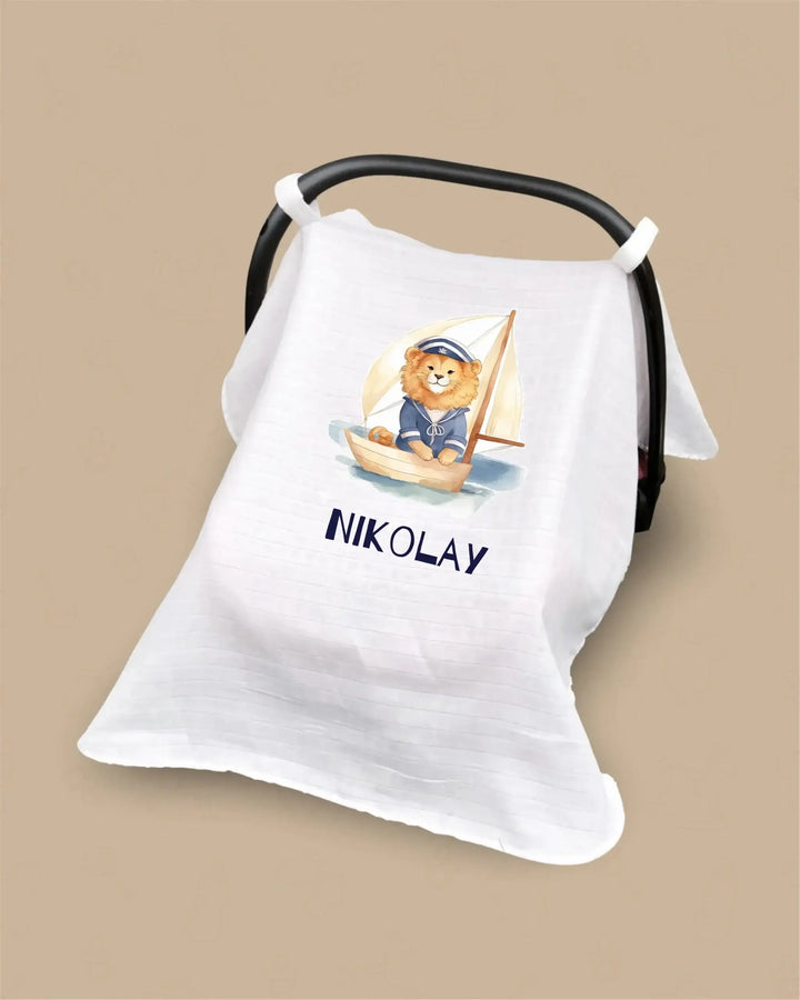 Gepersonaliseerde hydrofiele zonnekap met een zeilende leeuw en de naam 'Nikolay' voor autostoel 0+