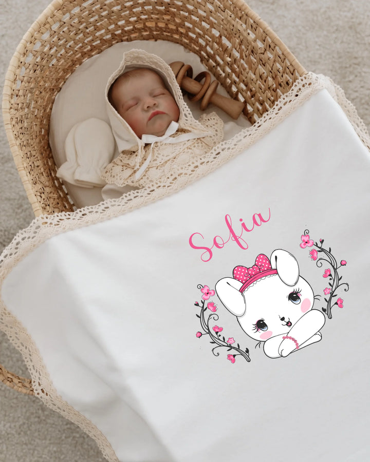Gepersonaliseerd babydekentje met konijntje en naam voor nieuwgeboren meisje in wieg.