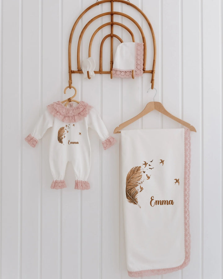 Veer & Vogels newborn girl set with feather design, personalized for Emma, featuring a romper, blanket, and hat.