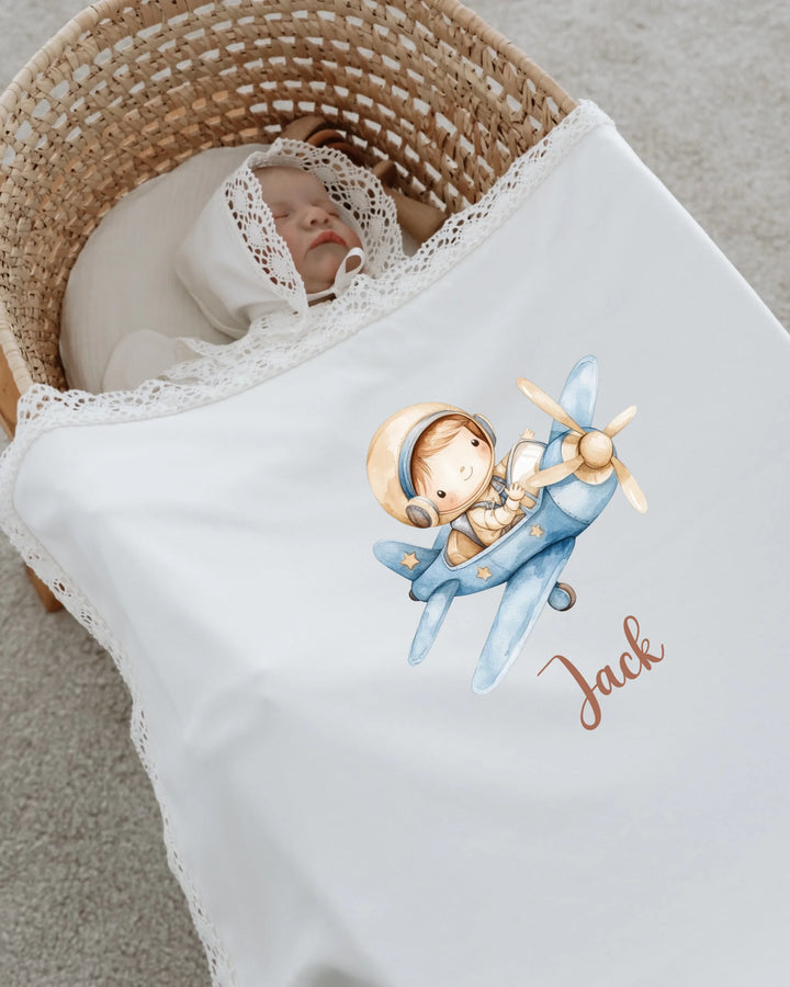 Newborn boy sleeping with personalized airplane blanket featuring the name Jack and an adorable pilot design.