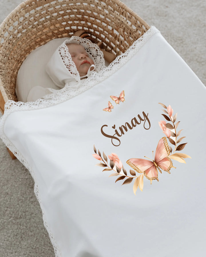 Baby girl swaddled in a blanket featuring a butterfly crown and personalized name, perfect newborn gift.