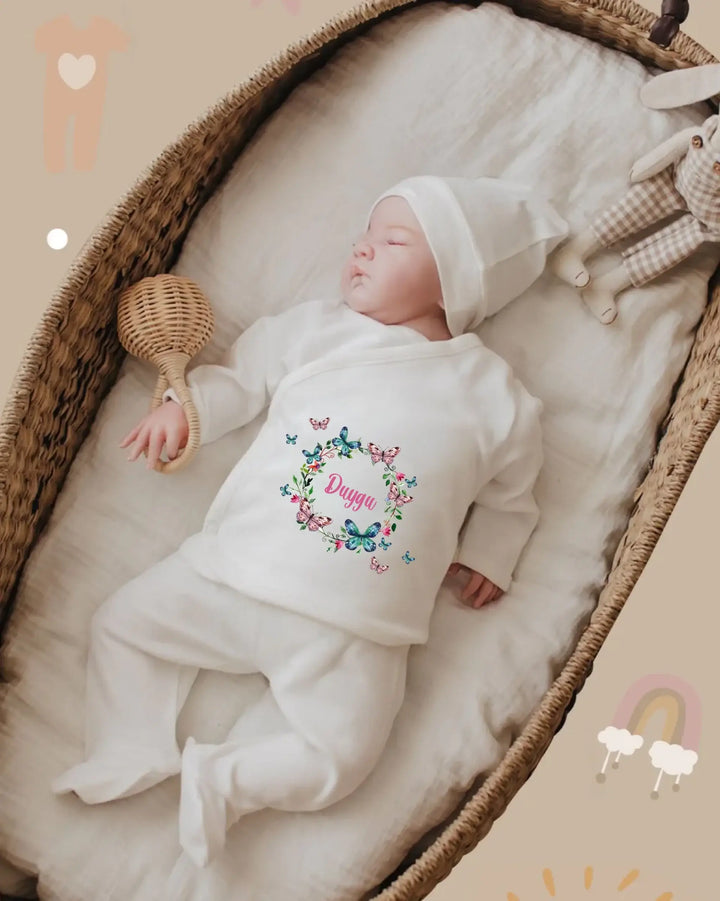 Gepersonaliseerde babyoutfit met naam, gemaakt van biologisch katoen, in een wiegje met een zachte deken.