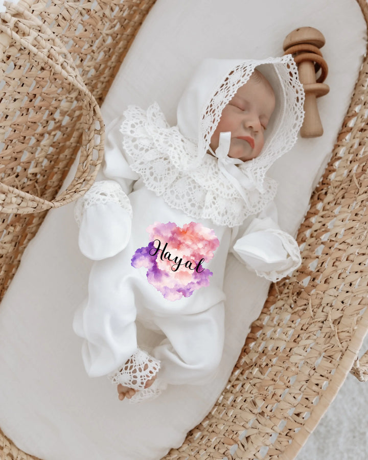 Gepersonaliseerde baby met een elegante witte outfit en kanten detail in een wieg.